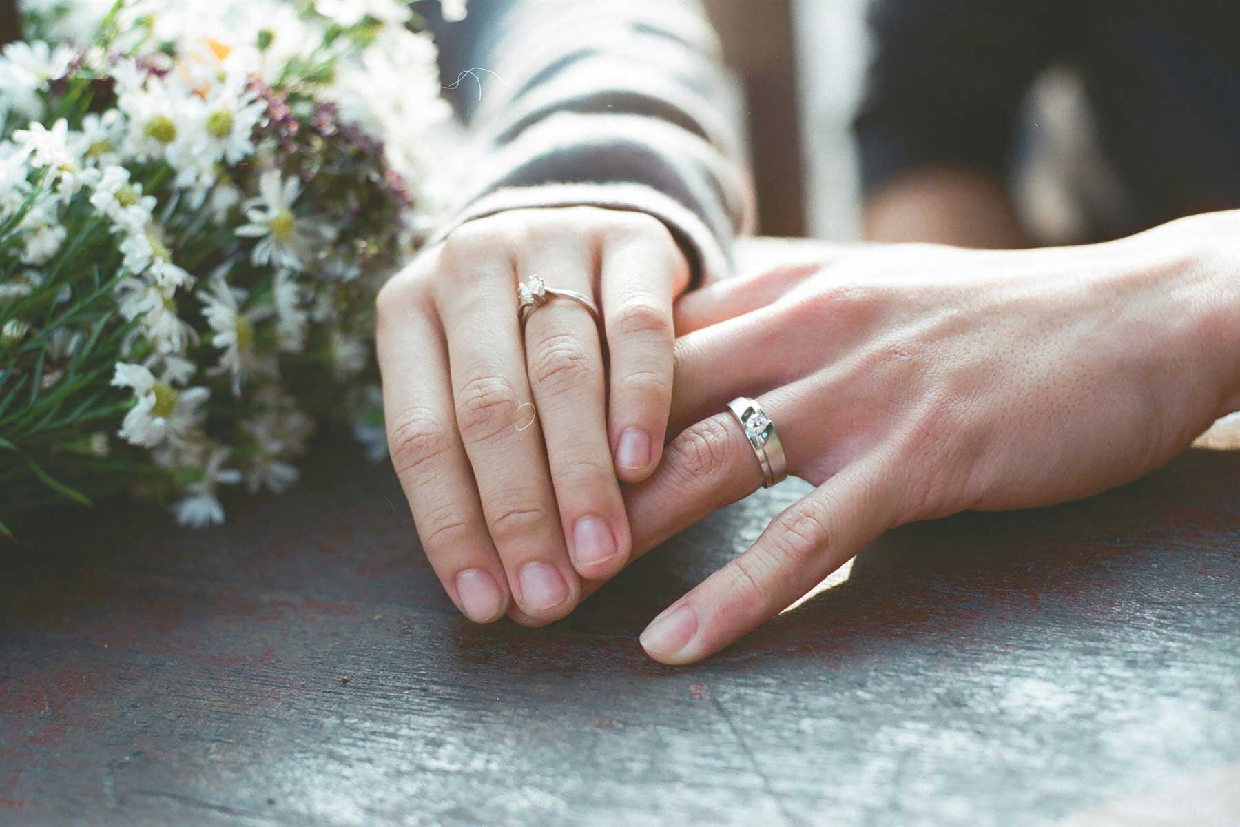 en man och en kvinnas händer med sina ringar